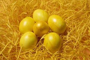 huevos de pascua amarillos sobre fondo de paja foto