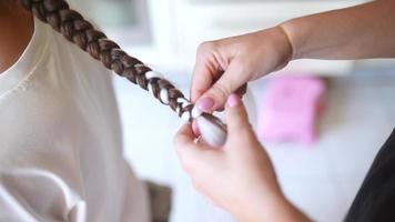 Girls braiding hair with a white strand of hair video