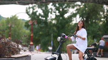 une jeune femme fait du scooter électrique par une journée ensoleillée video