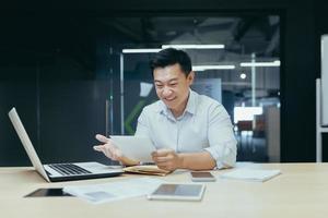 hombre de negocios en el trabajo, hombre asiático leyendo una buena carta del banco foto