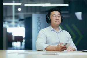 Asian boss business owner relaxing in office, listening relaxing and relaxing music photo