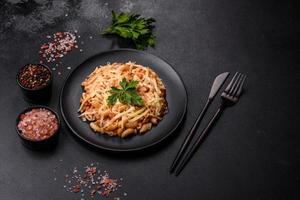 Tasty appetizing classic italian pasta with tomato sauce and cheese on plate on dark background photo