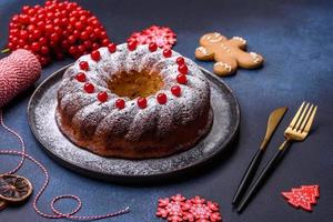 delicioso pastel de navidad redondo casero con bayas rojas en un plato de cerámica foto