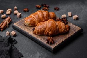 Fresh crisp chocolate croissants on wooden cutting board photo