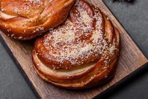 Delicious fresh crispy cinnamon buns sprinkled with coconut crumbs on a wooden cutting board photo