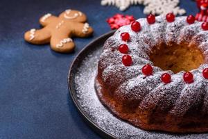 delicioso pastel de navidad redondo casero con bayas rojas en un plato de cerámica foto