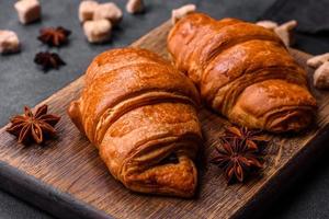 Fresh crisp chocolate croissants on wooden cutting board photo