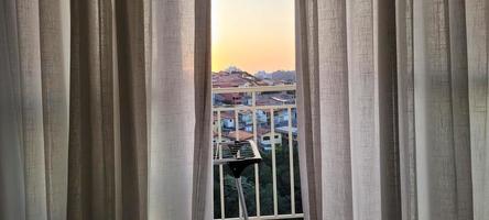 white linen curtain in apartment with sunset view in Brazil photo