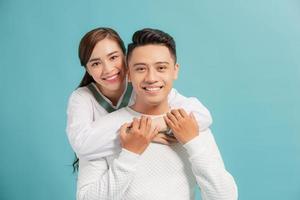 Happy couple embracing and looking camera on blue background photo