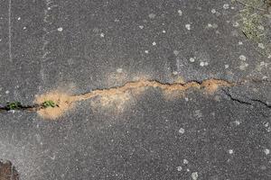 Detailed view on asphalt surfaces of different streets and roads with cracks photo