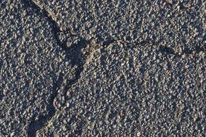 Detailed view on asphalt surfaces of different streets and roads with cracks photo