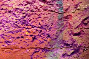 Texture of colorful graffiti paint on conrete and brick walls in red blue purple and silver photo