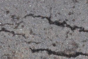 Detailed view on asphalt surfaces of different streets and roads with cracks photo