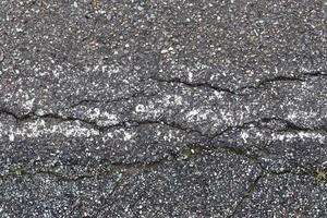 Detailed view on asphalt surfaces of different streets and roads with cracks photo