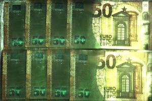 ilustración de billetes en euros brillantes con un aura kirliana verde a su alrededor. foto