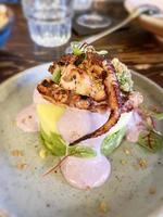 Grilled octopus with polenta and yogurt at a restaurant photo