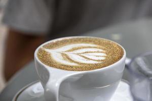 Flower pattern on a cafe latte at a restaurant photo