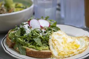 Avocado toast with radish egg and cheese at a restaurant photo