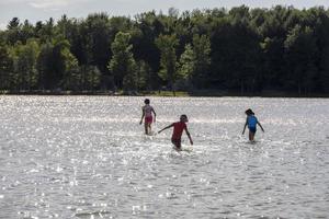 niños jugando en el agua de un lago en verano foto