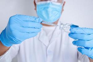 Doctors or scientists hold syringes and vials with the COVID-19 vaccine to try injections to treat patients in hospitals. Medical experiments prevent the spread of the coronavirus photo