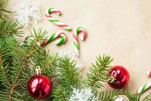 Festive christmas border with red and silver balls on fir branches and snowflakes on rustic beige background photo