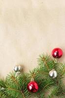 Festive christmas border with red and silver balls on fir branches and snowflakes on rustic beige background photo
