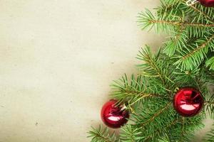 Fir tree branches decorated with red christmas balls as border on a rustic holiday background frame with copy space photo