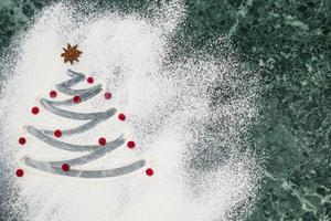 árbol de navidad con harina, bayas y especias de estrella de anís como decoración - horneado casero foto