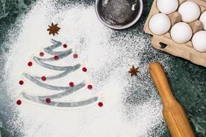 Christmas tree with the flour, berries and anise star spices as a decoration and rolling pin, eggs, strainer photo