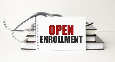 open enrollment, text on white notepad paper on white background near stethoscope photo