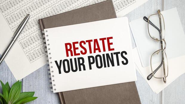 On the table charts, calculator and notebook with the RESTATE YOUR POINTS context photo