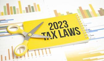 2023 tax laws text on the yellow notepad and chart background photo