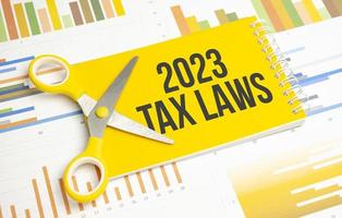 Texto de las leyes fiscales de 2023 en el bloc de notas amarillo y el fondo del gráfico foto
