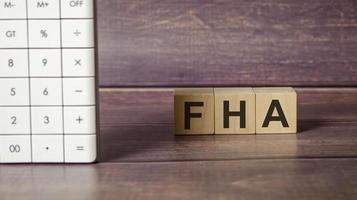 FHA - text is made up of letters on wooden cubes and wooden background photo