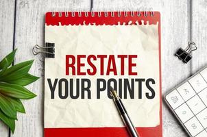 RESTATE YOUR POINTS. text on torn paper on red notepad photo