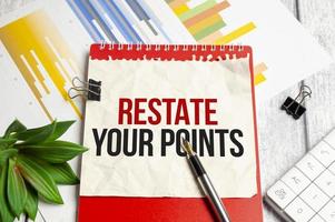 word RESTATE YOUR POINTS on yellow sheet of paper and red notepad photo