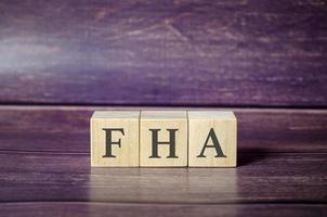 FHA - text is made up of letters on wooden cubes and wooden background photo