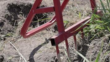 Rote Schaufel in Form einer Gabel im Garten. Wunderschaufel, handliches Werkzeug. manuelle Grubber. Der Grubber ist ein effektives Werkzeug für die Bodenbearbeitung. Bett Lockerung. nachhaltige landwirtschaftliche Werkzeuge. video