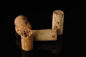 A close-up shot of some wine corks on a reflecting surface. photo