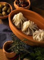 A vertical shot of a luxurious restaurant table with a gourmet khinkali dish photo