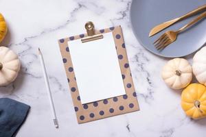 Autumn flat lay with blank tablet and decorative pumpkins on marble background top view photo