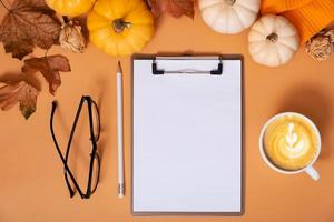 Flat lay blank tablet for text next to pumpkins and autumn leaves with coffee cup. Autumn theme mockup. photo