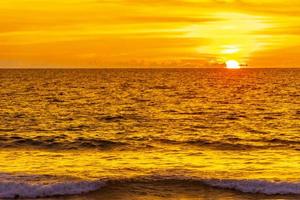 hermosa impresionante puesta de sol colorida y dorada en la isla de phuket, tailandia. foto