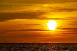 hermosa impresionante puesta de sol colorida y dorada en la isla de phuket, tailandia. foto