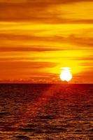 hermosa impresionante puesta de sol colorida y dorada en la isla de phuket, tailandia. foto