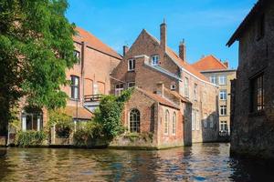 vista desde el canal a las antiguas casas de comerciantes de ladrillo en brujas, bélgica. vista de la ciudad de la antigua Europa medieval. foto