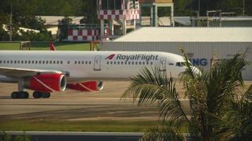 PHUKET, THAILAND NOVEMBER 30, 2019 - Royal Flight Boeing 757 VQ BTB taxiing after landing at Phuket International airport, focus on a foreground palm trees video