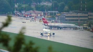 SOCHI, RUSSIA JULY 27, 2022 - Long shot, Boeing 737 of Nordwind arrived at Sochi airport. Passengers leave the plane. Jet plane on taxiway after rain. Tourism and travel concept video