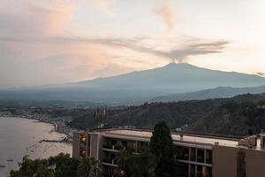 View of Hotel Elios overlooking volcanic Mount Etna with sky in background photo