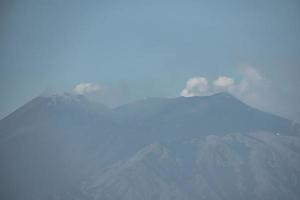 Volcanic Mount Etna with blue sky in background during summer photo